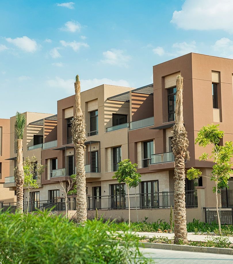 Low-rise buildings among palm trees at District 5, New Cairo